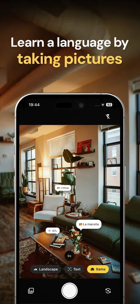 Linkoglot's camera pointed at a living room, with word labels in three languages on a chair, a plant pot and a book